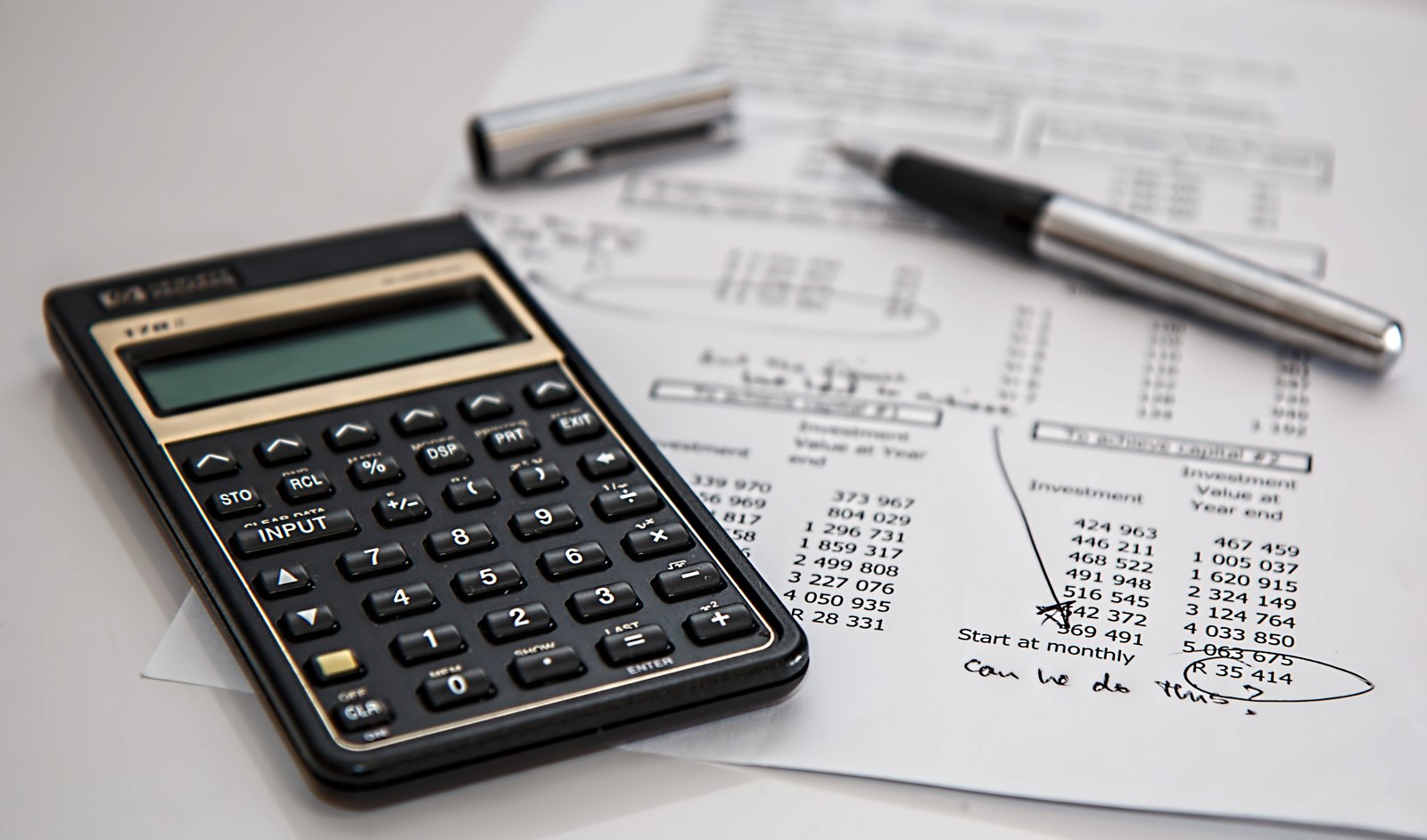 Calculator and pen resting on financial paperwork